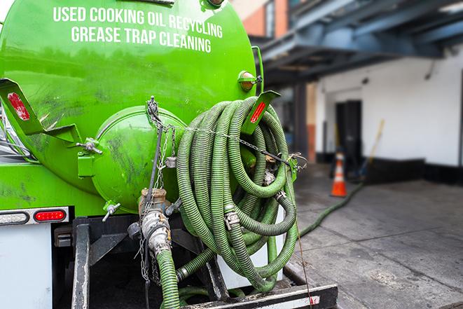 a grease trap pumping service in action at a commercial building in Encino